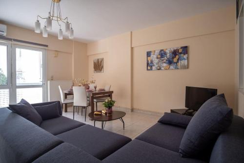 a living room with a blue couch and a table at Thetis Luxury Apartment in Samos