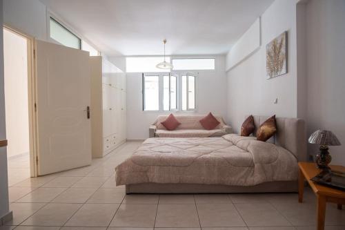 a bedroom with a bed and a couch in it at Thetis Luxury Apartment in Samos