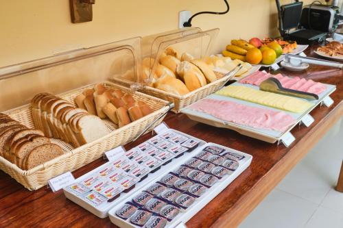 een tafel met manden brood en andere voedingsmiddelen bij Pousada Villa Piemonte in Ubatuba