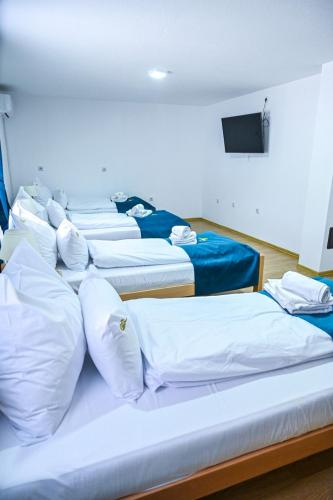 a row of beds in a room with a tv at Apartmani Leburic in Prnjavor