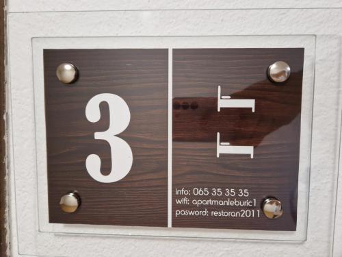 a sign on a wall with a number on it at Apartmani Leburic in Prnjavor