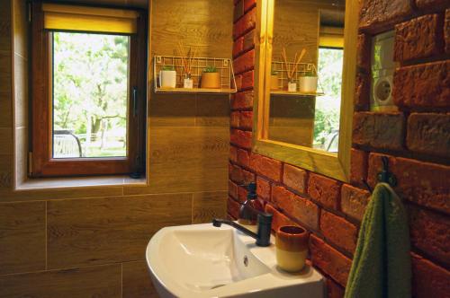 Łazienka z umywalką i ceglaną ścianą w obiekcie Domki Nad Potokiem574067621 w mieście Ustrzyki Dolne
