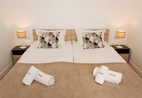 una camera con un letto con due cuscini e due lampade di Seaview Haven - Elegant 2BD Flat in Balchik by Flat Mаnager a Balchik