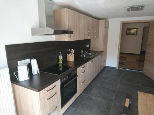 a kitchen with wooden cabinets and a black counter top at Da Camillo in Oberstaufen