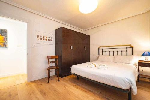 a bedroom with a large bed and a desk at La Capilla Apartamento in Oviedo