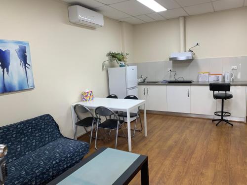 a living room with a couch and a table and a kitchen at Chadstone Holiday E2 Villa in Oakleigh