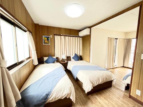 two beds in a room with two windows at Japanese House-ueno/asakusa/oshiage/ginza/narita in Tokyo