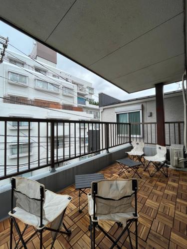 a balcony with chairs and tables on a building at Japanese House-ueno/asakusa/oshiage/ginza/narita in Tokyo
