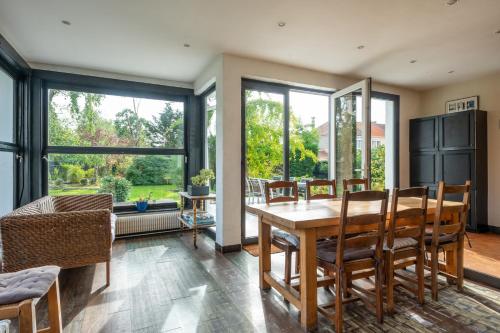 une salle à manger avec une table et des chaises dans l'établissement Grande Maison Familliale, à Coulogne