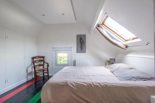 une chambre avec un lit, une fenêtre et une chaise dans l'établissement Grande Maison Familliale, à Coulogne