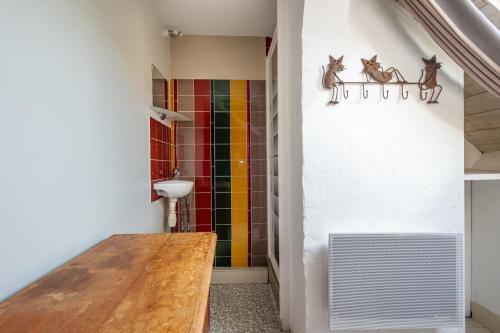 un couloir avec une table en bois et un mur coloré dans l'établissement Grande Maison Familliale, à Coulogne