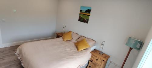 a bedroom with a bed with yellow pillows on it at Fal Mor House in Belmullet