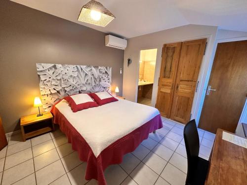 a bedroom with a large bed with red pillows at Chambres d'hôtes les Clapas in Chauzon