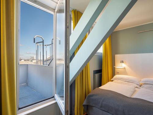 a bedroom with a bed and a large window at The New Yorker Hotel Köln-Messe in Cologne