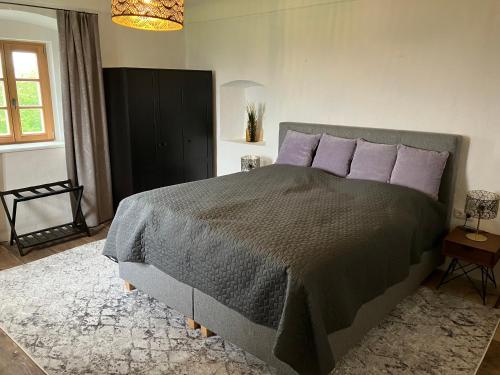 een slaapkamer met een groot bed met paarse kussens bij Baronigg Weingartengut 