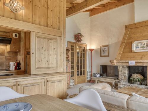 Elle comprend un salon doté de murs en bois et d'une cheminée. dans l'établissement Appartement 2 chambres avec balcons, Wifi et parking à proximité des pistes - Megève Jaillet - FR-1-453-292, à Megève