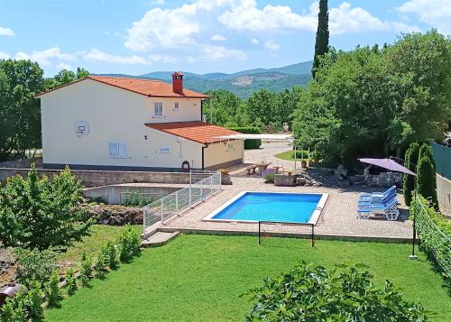 un patio trasero con piscina y una casa en House for vacation Runac en Imotski