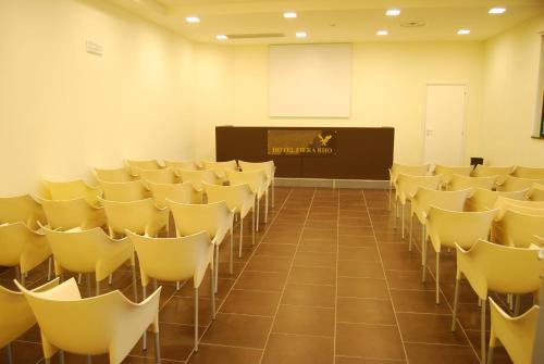 a lecture room with chairs and a podium with a screen at Hotel Fiera Rho in Rho