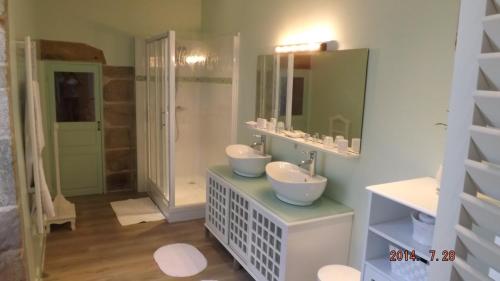 ein Badezimmer mit 2 Waschbecken und einem Spiegel in der Unterkunft Domaine de Nalou 
