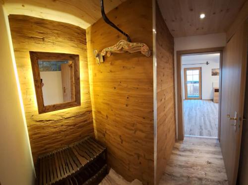Zimmer mit einer Holzwand mit einer Bank und einem Spiegel in der Unterkunft Haus Silbertann in Schönau am Königssee