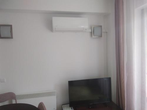 sala de estar con TV de pantalla plana en una habitación en Слънчев апартамент в к-с Мурите, en Razlog