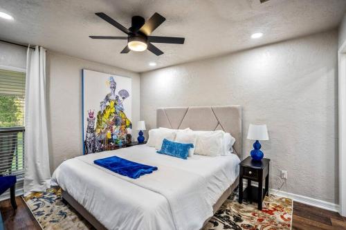 a bedroom with a white bed with a ceiling fan at Royal Palm at Lake Conroe NO PARTIES NO SMOKING 1000k FINE in Montgomery