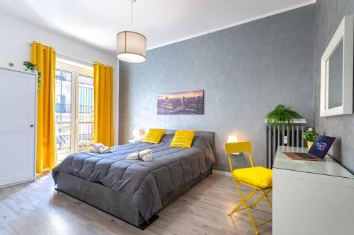 a bedroom with a large bed and a yellow chair at URBAN House in Rivoli