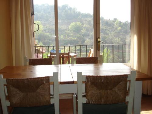 a dining room table with chairs and a large window at APARTAMENTS PUIG GILI in Mura