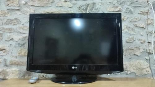 um monitor de computador sentado em cima de uma mesa de madeira em Albergue Casa Fumenal em Padarniu