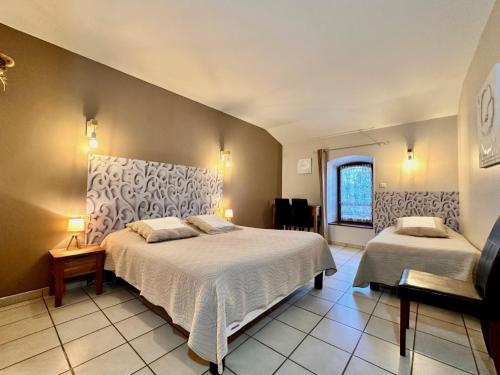 a large bedroom with two beds and a window at Chambres d'hôtes les Clapas in Chauzon