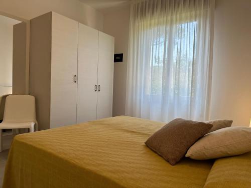um quarto com uma cama grande e uma janela em Villa Tre Pini em Lignano Sabbiadoro