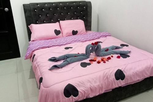 a bed with a pink bedspread with hearts on it at The 88 Homestay in Batu Pahat