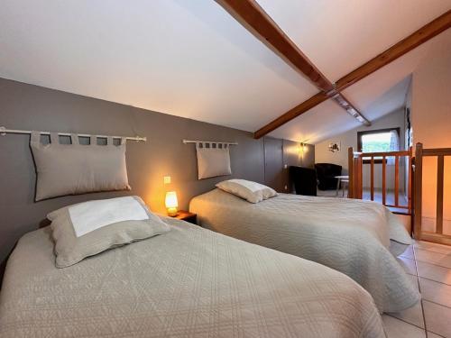 ChauzonにあるChambres d'hôtes les Clapasのベッドルーム1室(ベッド2台付)、バルコニーが備わります。