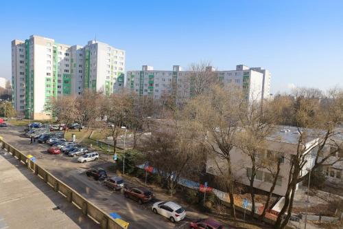 a parking lot with cars in a city with tall buildings at Sunny House Two in Bratislava