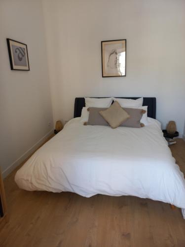 a bed with white sheets and pillows in a bedroom at Coeur d'Uzès in Uzès