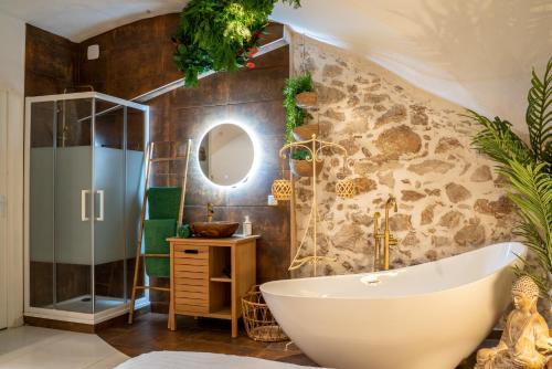 uma casa de banho com uma banheira e um chuveiro em vidro. em Le Bali Safranier Vieil Antibes em Antibes