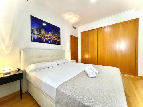 ein Schlafzimmer mit einem Bett und einem TV an der Wand in der Unterkunft Luxury Duplex 200 M2 Terrace Parking StayInSeville in Sevilla