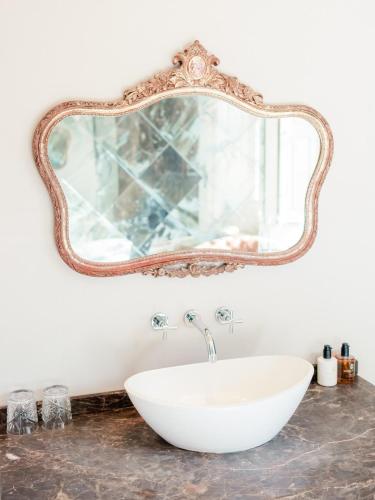 a bathroom with a white sink and a mirror at Newton Hall in Chathill