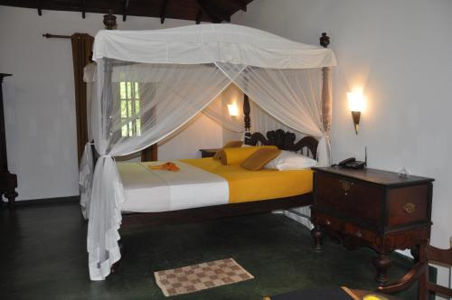 1 dormitorio con cama con dosel y vestidor en Refresh Cabana Gardens, en Kataragama