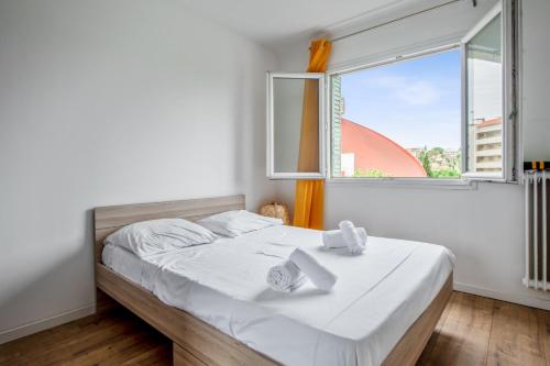 une chambre avec un lit blanc et une fenêtre dans l'établissement Appartement Lauriers - Welkeys, à Antibes