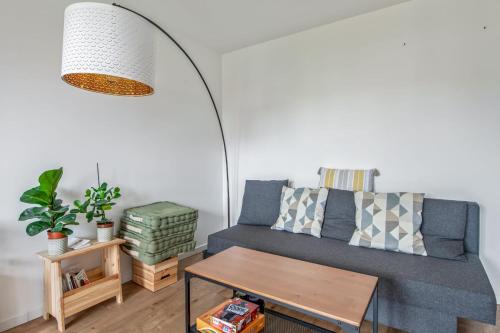 un salon avec un canapé bleu et une table dans l'établissement Appartement Lauriers - Welkeys, à Antibes