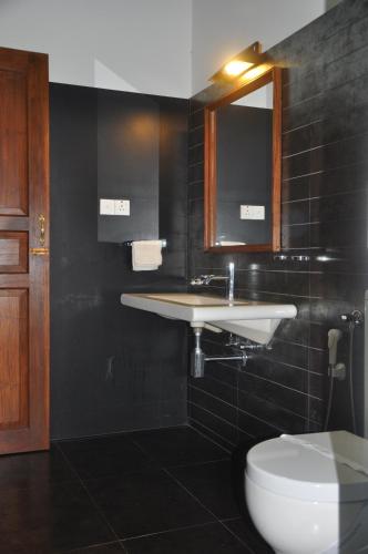 a bathroom with a sink and a toilet at Refresh Cabana Gardens in Kataragama