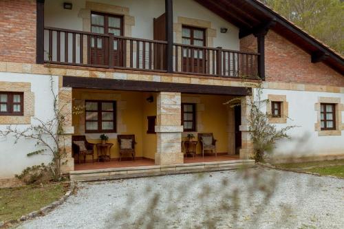 an outside view of a house with a balcony at El Molino de Bonaco in San Vicente de la Barquera