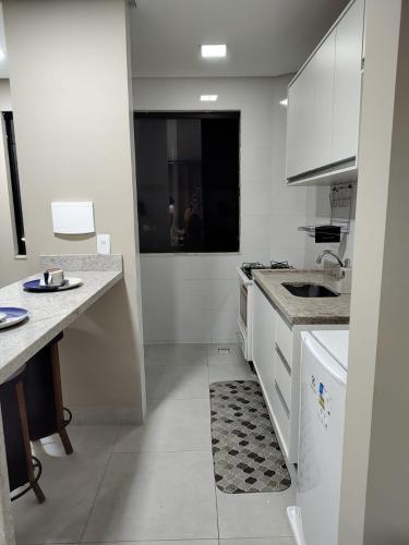 a white kitchen with a sink and a counter at Apartamento 2 Quartos - 5 minutos do São João de Petrolina in Petrolina