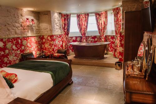 a bedroom with a bed and a bath tub at Newton Hall in Chathill