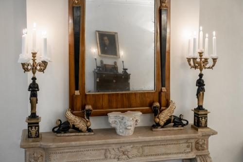 a mirror sitting on top of a table with candles at La Casa nel Borgo in Piadena