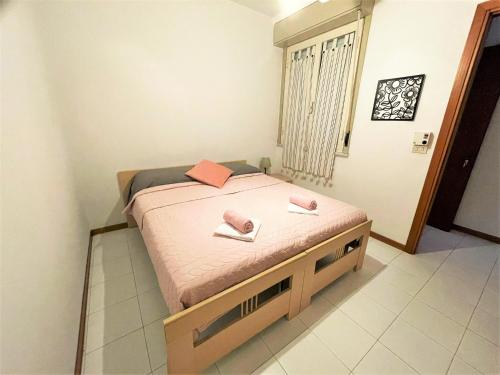 ein Schlafzimmer mit einem Bett mit rosa Handtüchern darauf in der Unterkunft Casa Lucia in Letojanni