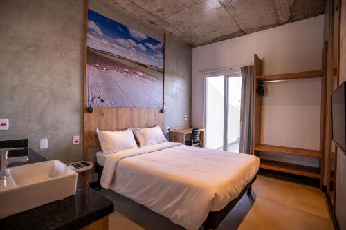 a bedroom with a bed and a sink in it at CAMPOS DE HOLAMBRA INN in Paranapanema