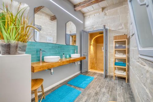 a bathroom with two sinks and blue tiles at Le Petit Voyage - CHILL OUT in Cospicua