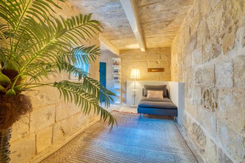 um quarto com uma cama numa parede de pedra em Le Petit Voyage - CHILL OUT em Cospicua